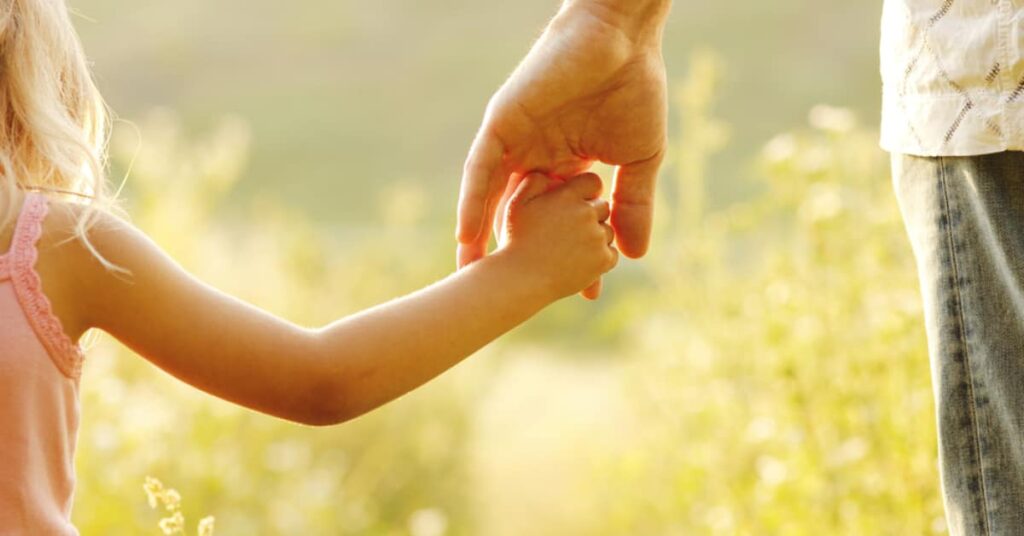 adult holding childs hand, concept of Change of Circumstances for NJ Custody & Parenting Time