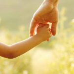 adult holding childs hand, concept of Change of Circumstances for NJ Custody & Parenting Time