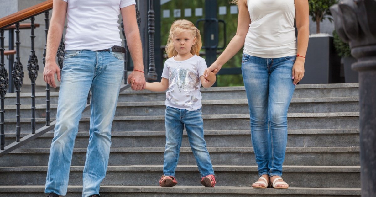 child holding hands of 2 adults, concept of Creating an Effective Co-Parenting Plan That Works