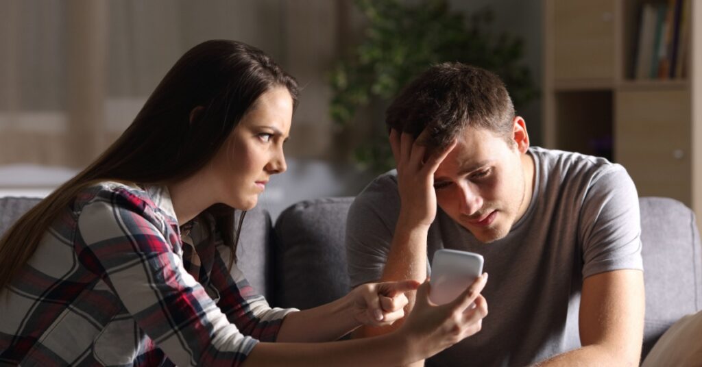 upset girl showing upset guy cell phone, concept of Is Adultery Grounds for Divorce in New Jersey?