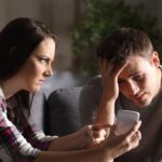 upset girl showing upset guy cell phone, concept of Is Adultery Grounds for Divorce in New Jersey?