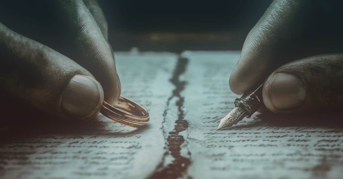 How to Start the Divorce Process in NJ? 1 couples hands with pen and ring with crack inbetween, concept of how to start the divorce process.